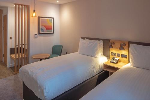 桑德兰Holiday Inn Sunderland - City Centre, an IHG Hotel的酒店客房设有两张床和一张桌子。
