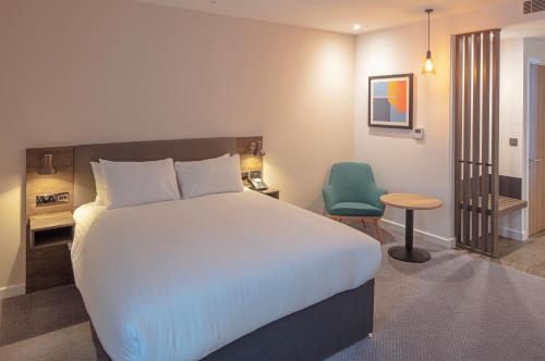 桑德兰Holiday Inn Sunderland - City Centre, an IHG Hotel的一间卧室配有一张大床和一张绿色椅子