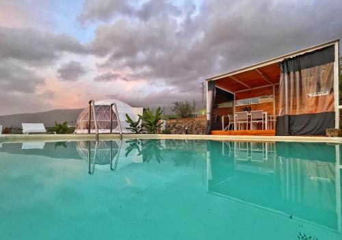 ArafoDomo Volcano Suite Experience的一座带游泳池和大楼的房子