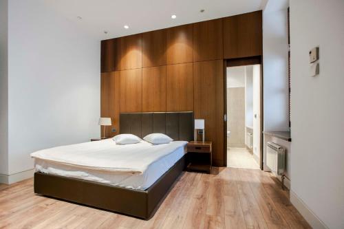 华沙1898公寓酒店的一间卧室设有一张大床和木墙