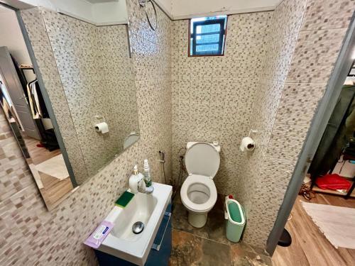 达喀尔Dakar cosy maison avec terrasse by immo kit bnb的一间带卫生间、水槽和镜子的浴室