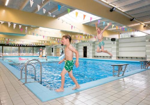 ZevenhuizenRecreatiepark de Koornmolen的两个男孩跳进游泳池
