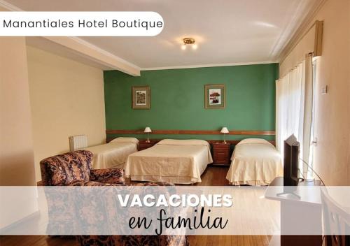 维多利亚Manantiales Hotel Boutique的绿墙客房内的两张床