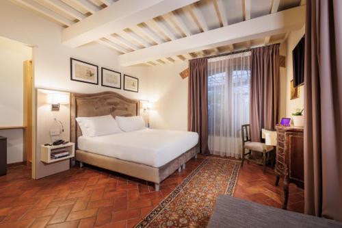 佛罗伦萨大使馆酒店的配有一张床和一张书桌的酒店客房