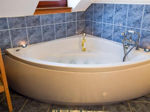 克罗斯盖茨班克黑德农场乡村别墅的浴室设有浴缸,铺有蓝色瓷砖。