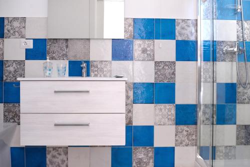 切萨雷奥港Villa Sofia Bed and Breakfast的浴室设有白色梳妆台和蓝色及白色瓷砖