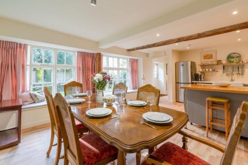 赛伦塞斯特Woodmancote Manor Cottage的厨房以及带桌椅的用餐室。