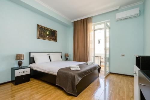 第比利斯Rustaveli Three Bedroom Apartment with Amazing views的一间卧室配有一张床和一台电视
