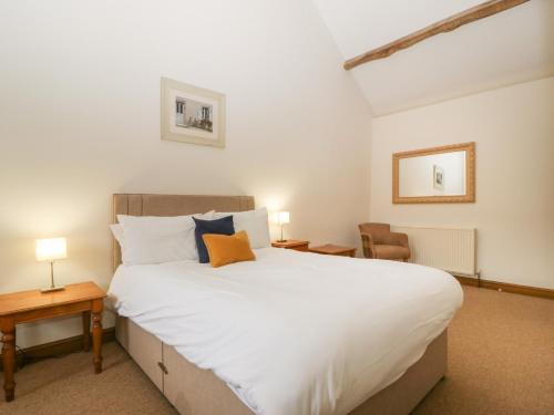 伍斯特Clover Patch Cottage的卧室配有一张白色大床和一把椅子