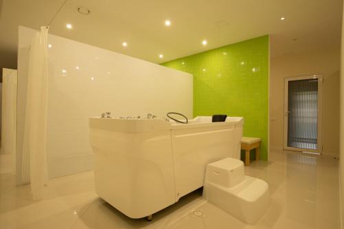 萨塔尼夫ARDEN PALACE Medical Resort & SPA的浴室设有白色浴缸和绿色墙壁。