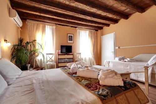 威尼斯卡里萨旅馆的一间卧室配有两张带白色床单的床
