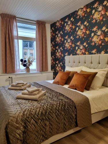 GennepbijDorien的一间卧室配有一张带花卉壁纸的大床