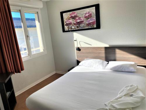 阿维尼翁圣玛尔特公寓式酒店的卧室配有白色的床和窗户。