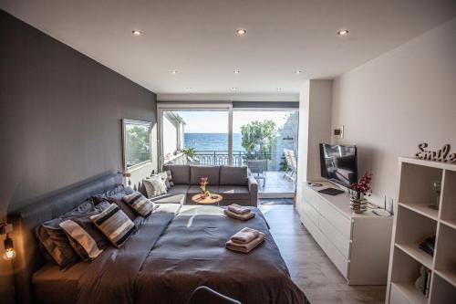 伊泰阿Kalafatis beach home的一间卧室设有一张大床和大窗户