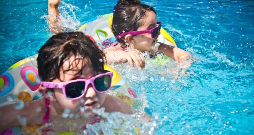 卡达斯诺瓦斯Tainá e Cezar's Park Caldas Novas的2名儿童使用带太阳镜的游泳池