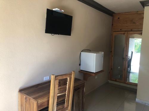 纳瓜坎布里酒店的一间设有壁挂式电视和冰箱的客房