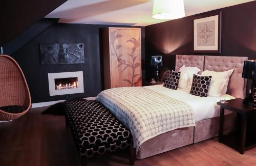 爱丁堡虎皮百合酒店的一间卧室配有一张床和一个壁炉