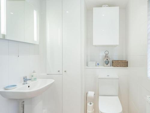 灵伍德Tea Pot Cottage的白色的浴室设有水槽和卫生间。