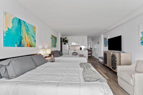 代托纳海滩oceanside inn的白色卧室设有一张大床和一张沙发