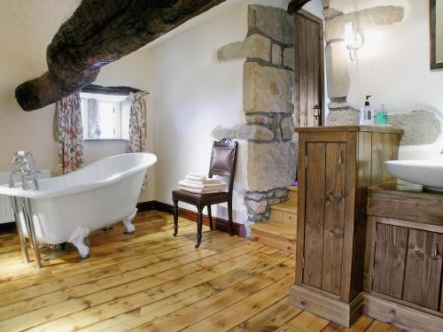 哈沃斯Far View Cottage的带浴缸和石墙的浴室。