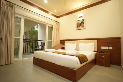 MundakāyamRoyalton Residency的一间卧室设有一张床和一个大窗户