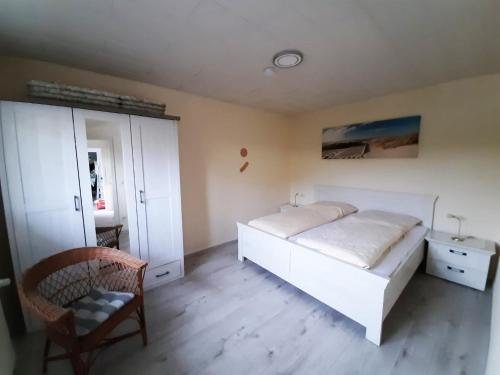塞巴特阿尔贝克Inseltraum的卧室配有白色的床和椅子