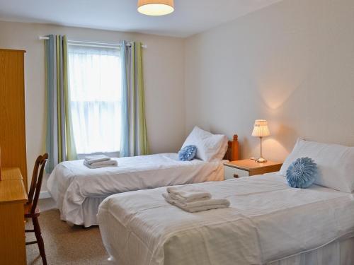 Stokeinteignhead蓝钟乡村别墅的酒店客房设有两张床和窗户。