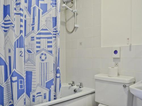 Stokeinteignhead蓝钟乡村别墅的浴室设有蓝色和白色的淋浴帘