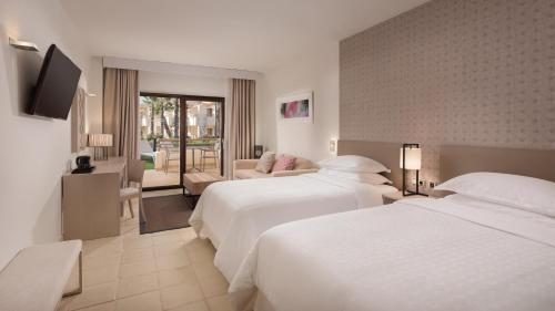 弗安特阿拉莫Ona Hacienda del Álamo Golf Resort的酒店客房,设有两张床和一张沙发