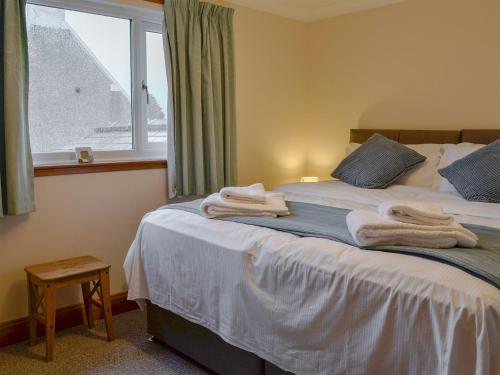 斯特兰拉尔Hawthorn Cottage的一间卧室配有带毛巾的床