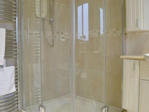 斯特兰拉尔Hawthorn Cottage的浴室里设有玻璃门淋浴