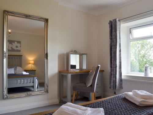 HolmewoodLing Farm Cottage的一间卧室配有镜子、一张床和一把椅子