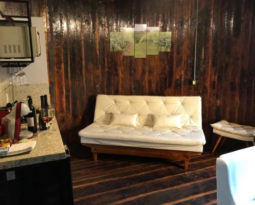 本图贡萨尔维斯Villa Vinicolla Hospedagem Conceito的木墙房间内的白色沙发