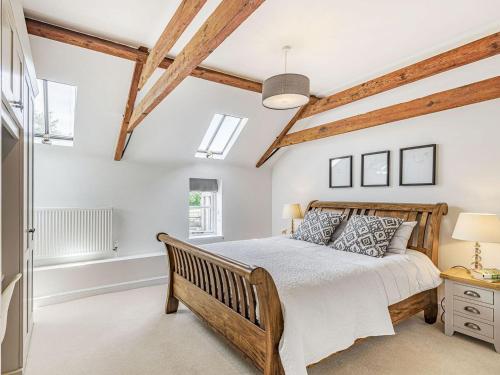 BraunstonThe Granary的一间卧室设有一张木床和一个窗户。