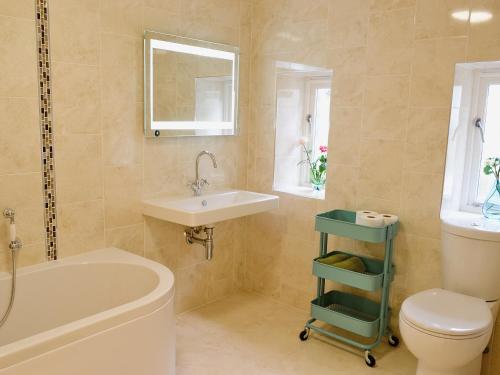 圣贾斯特Bowji的浴室配有盥洗盆、卫生间和浴缸。