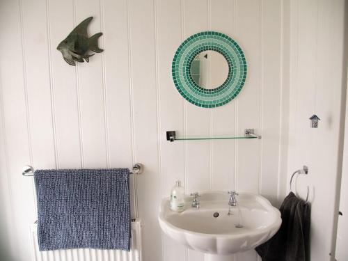 FelphamPebble Cottage的白色的浴室设有水槽和镜子