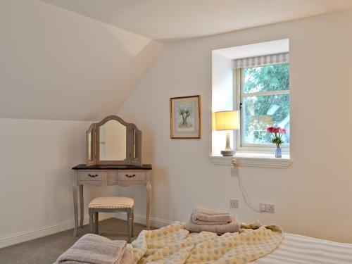 GartocharnSt Ronans Place的一间卧室配有一张床、一张桌子和一个窗户。