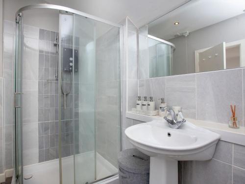 StokeinteignheadOld Seaway Mews的白色的浴室设有水槽和淋浴。