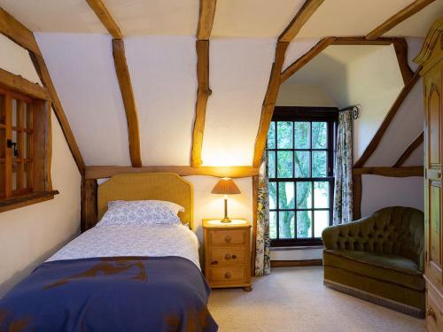Milnathort海罗夫特酒店的卧室配有床、椅子和窗户。