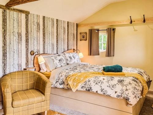 韦尔斯Walnut Lodge的一间卧室配有一张床和一把椅子
