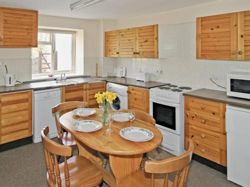 BanwellMaxmills Cottage - E1852的一间带木桌和椅子的厨房以及一间用餐室
