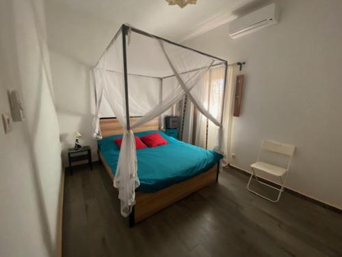 RufisqueVilla Idaka的一间卧室配有一张带天蓬的床