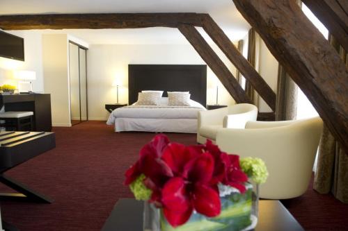 卢瓦尔河畔叙利贝尔杰文酒店的配有一张床和花瓶的酒店客房
