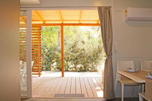 托里德欧索Villaggio Camping Sentinella的通往带桌椅的天井的开放式门