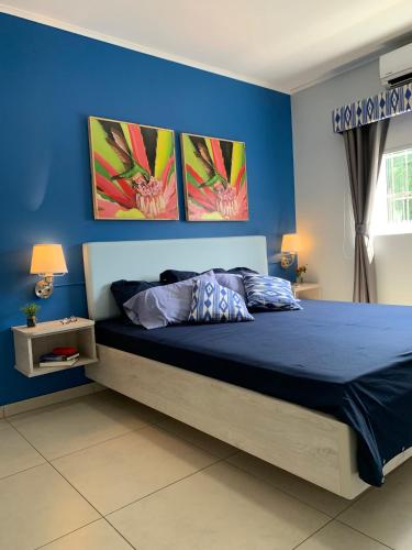 威廉斯塔德Lilu Apartments Curaçao的卧室配有一张墙上三幅照片的床