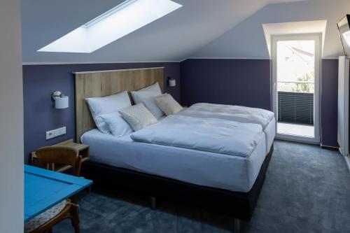 塞海姆-尤根海姆Hotel Brasserie Chaussee的一间卧室设有一张蓝色墙壁的大床