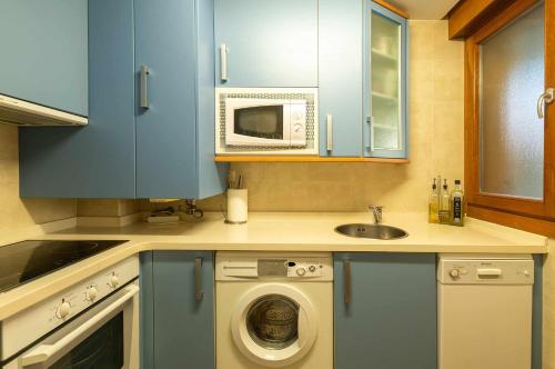 巴罗德亚尼斯Apartamento Mirador Playa de Barro的厨房配有洗衣机和微波炉。
