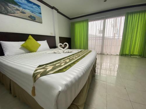 卡塔海滩Sue@Cozy Guesthouse的一间卧室配有一张带绿色窗帘的大床