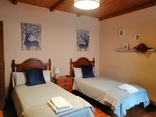 萨莫斯Casa Licerio的一间卧室配有两张带蓝色枕头的床