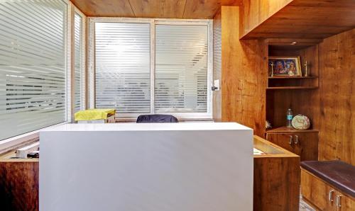 班加罗尔Treebo Trend SK Suites的厨房配有白色的柜台和窗户。
